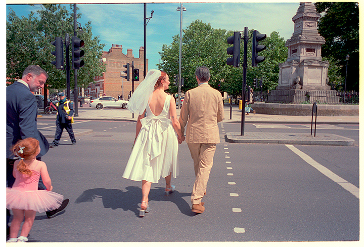 Bride and groom walking through South London after their wedding ceremony